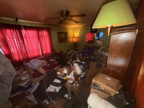 Living room packed with boxes, furniture and clutter before removal