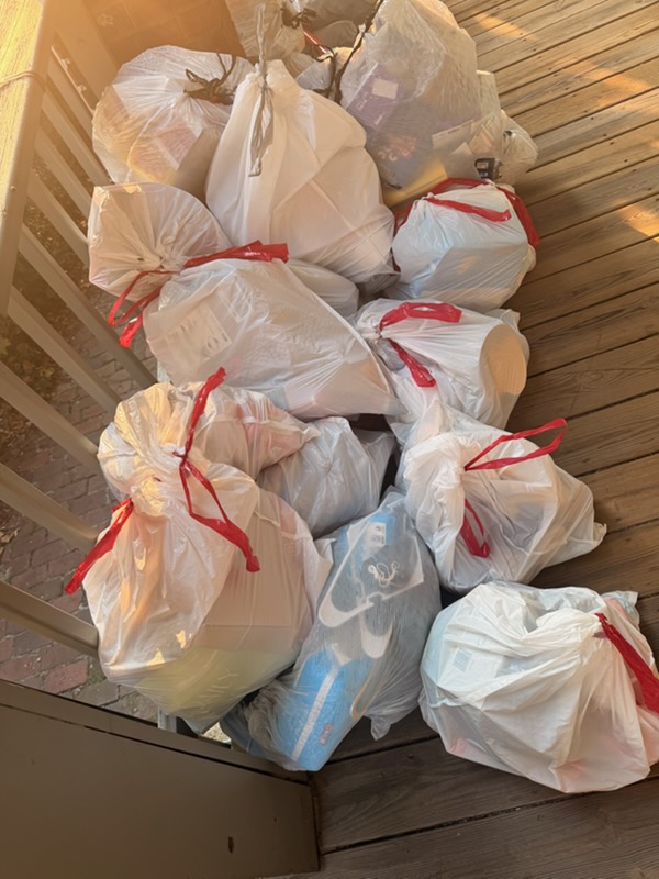 Tied bags of household junk gathered in a corner for loading