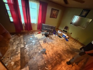 The same living room cleared down to the bare floor after junk removal