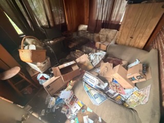 Boxes and loose paper piled across a room before removal