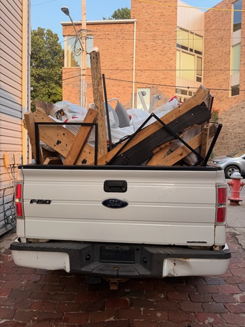 Pickup truck loaded with furniture and scrap wood from a cleanout